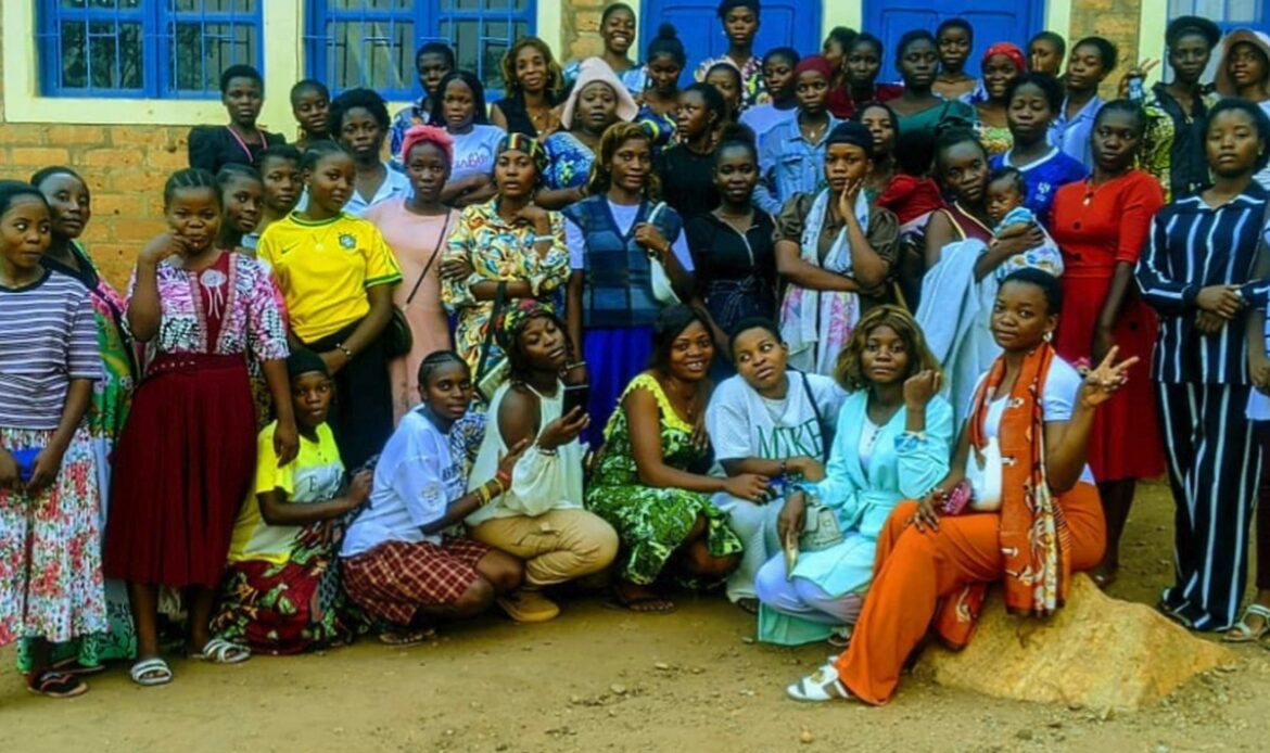 Jeunes femmes posées en groupe devant un bâtiment aux fenêtres bleues